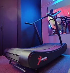 A treadmill shot from a low angle with a mirror and blue light in the background