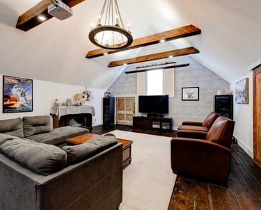 family media room with vaulted ceiling and beams