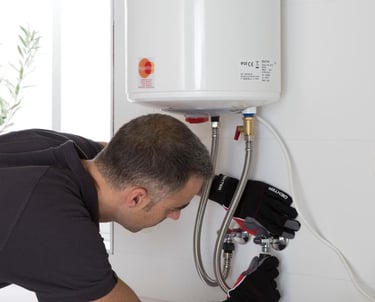 a man in a black shirt is fixing a tankless water heater