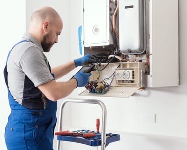 a man in overalls and overalls working on a gas stove
