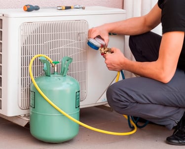 a man in a black shirt is using a hose to fix a gaskettle