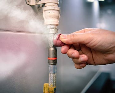 a person holding a hose and a hose in a kitchen