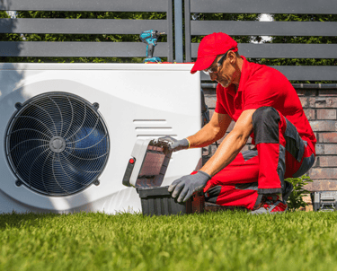 a man in a red shirt and a red hat is working on a white refrigerator