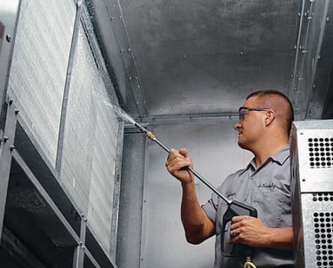 a man in a gray shirt is spraying a cell phone