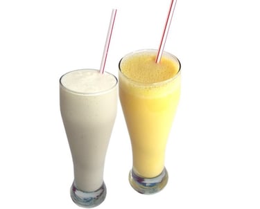 two glasses of milkshake with a drink in front of them