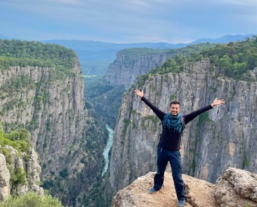 a man standing at Tazi Kanyon with his arms up and arms up