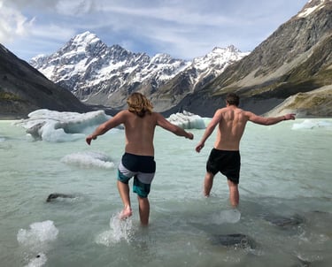 two travellers enjoying a swim in the hooker glacier, under mount cook 