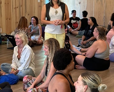 a woman in a white shirt is standing in a circle with other people