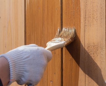 Application d'une protection pour bois sur une clôture verticale à l'aide d'un pinceau
