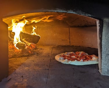wood fired pizza oven cooking a pizza