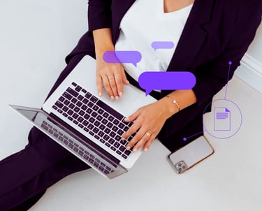 An overhead shot of a female professional with laptop and phone on her lap as she works.