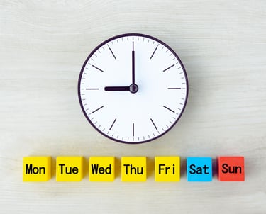 A black and white analog face with a line of 7 small cubes lined up below labeled with days of week.