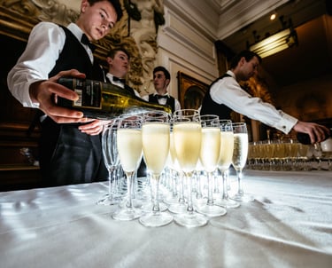 a waiter is pouring champagne into glasses of champagne