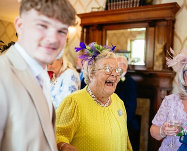 Guests share laughter at a wedding reception in Decourcey’s Manor, Cardiff, full of colour, joy and character.