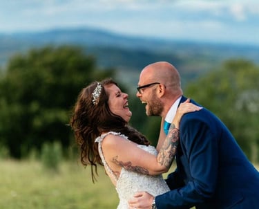 Bride and groom laughing outdoors at South Wales countryside wedding, captured by photographer Owen Mathias