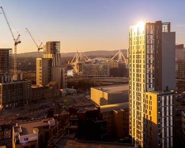 a city skyline with a sun setting in the background
