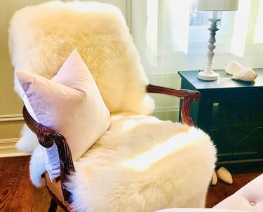 traditional chair with sheepskin and pink cushion