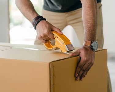 Man packing a product into a cardboard box.