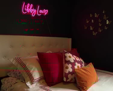 a bed with a neon sign that says hello to you