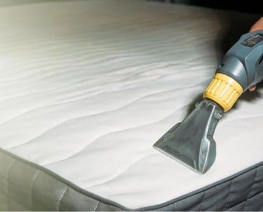 a person cleaning a mattress with a vacuum