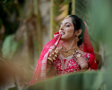 Close-up of joyful Indian dulhan in red bridal choli and jewellery during wedding photoshoot in Vado