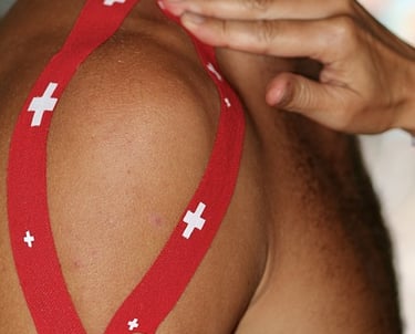 Sports Therapist applying tape to a client's shoulder