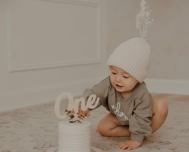 a baby boy is sitting on the floor with a cake