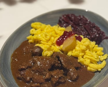 Rinderragout auf dem Teller mit Spätzle, Soße, Rotkraut