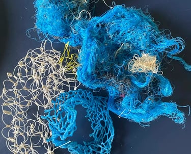 A collection of tangled blue and white plastic fishing nets and ropes representing ocean pollution.