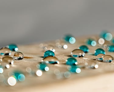 turquoise and clear water droplets on a wooden surface