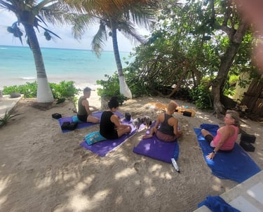 a group of people doing yoga on a beach playa del carmen