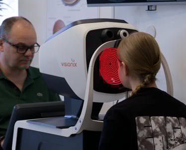 Patient undergoing an eye exam with a Visionix diagnostic scanner at an optometrist.