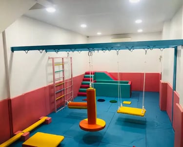 sebuah ruang sensori intergasi anak dengan ayunan perosotan dan kolam bola