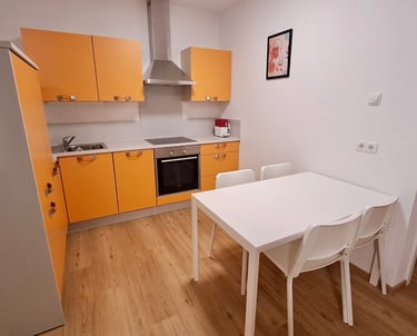 a kitchen with a table and chairs in the middle of the room