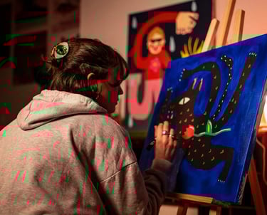 a woman is painting a picture of a cat