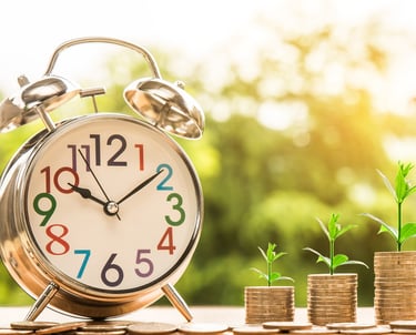 clock next to coins that grow in value more and more over time thanks to compound interest