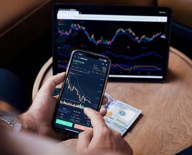 guy managing investments with phone and computer