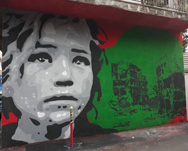Social-themed mural with female face and ruined buildings, urban art by Poliops.