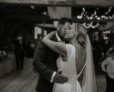 a bride and groom kissing in a barn wedding
