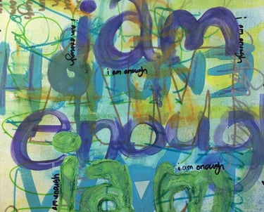 A layered declaration of worth: “I am enough” painted in varying colors, sizes, and tones.