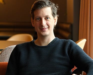 a man sitting on a couch with a remote control