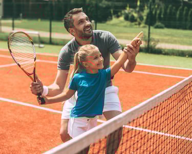 a man and a little girl playing tennis