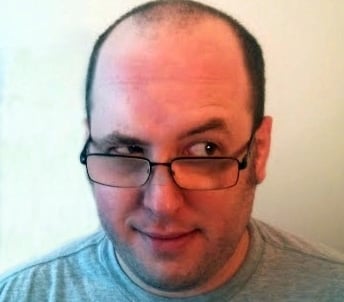 a man with glasses and a gray shirt