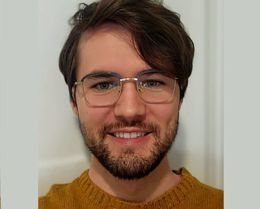 smiling man with glasses,, beard, and brown hair