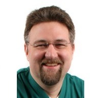 headshot of a man with a beard, glasses, and brown hair