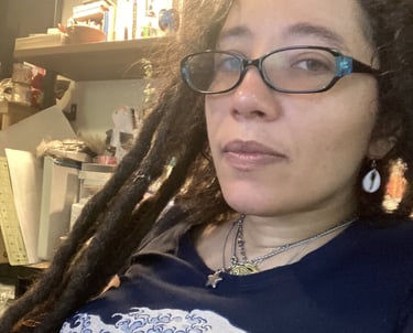 a woman with dreadlocks and glasses