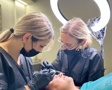 Darina Sendrau y una estudiante en proceso de un procedimiento de microblading/micropigmentación.