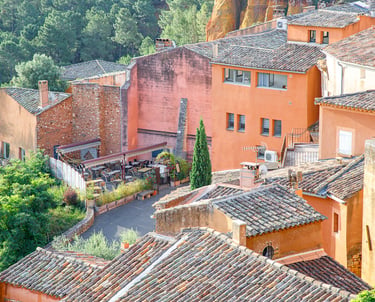 Aerial view of terracotta ochre houses and tiled roofs in Roussillon, a scenic village in Provence, France.