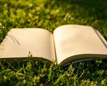 Aufgeschlagenes Buch auf einer gruenen Wiese mit Trauerrede