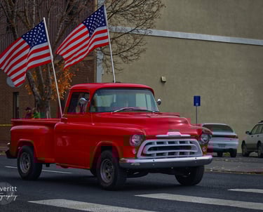 a red truck with two americans flags on it